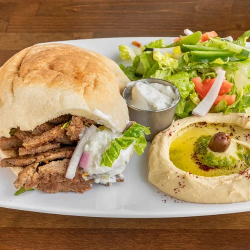 Gyro Sandwich - Gyro wrap with seasoned meat, fresh veggies, and house sauce in warm pita.