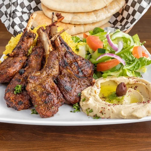 Lamb Chops Plate - Perfectly grilled lamb chops seasoned with Mediterranean spices, served with rice and fresh salad.